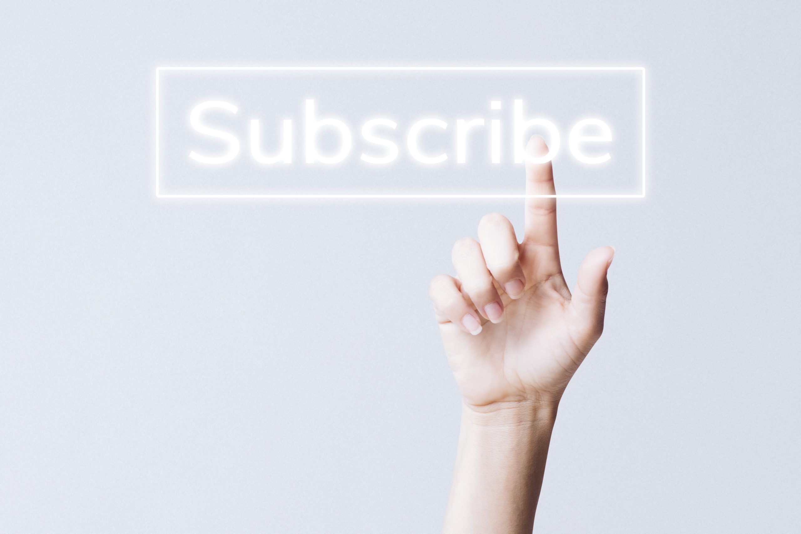 Hand clicking subscribe button on social media